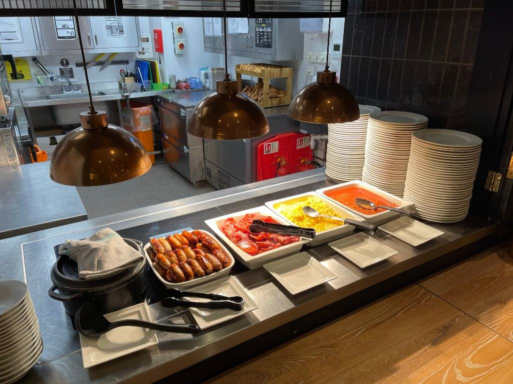 English breakfast: porridge, sausages, bacon, scrambled eggs, baked beans